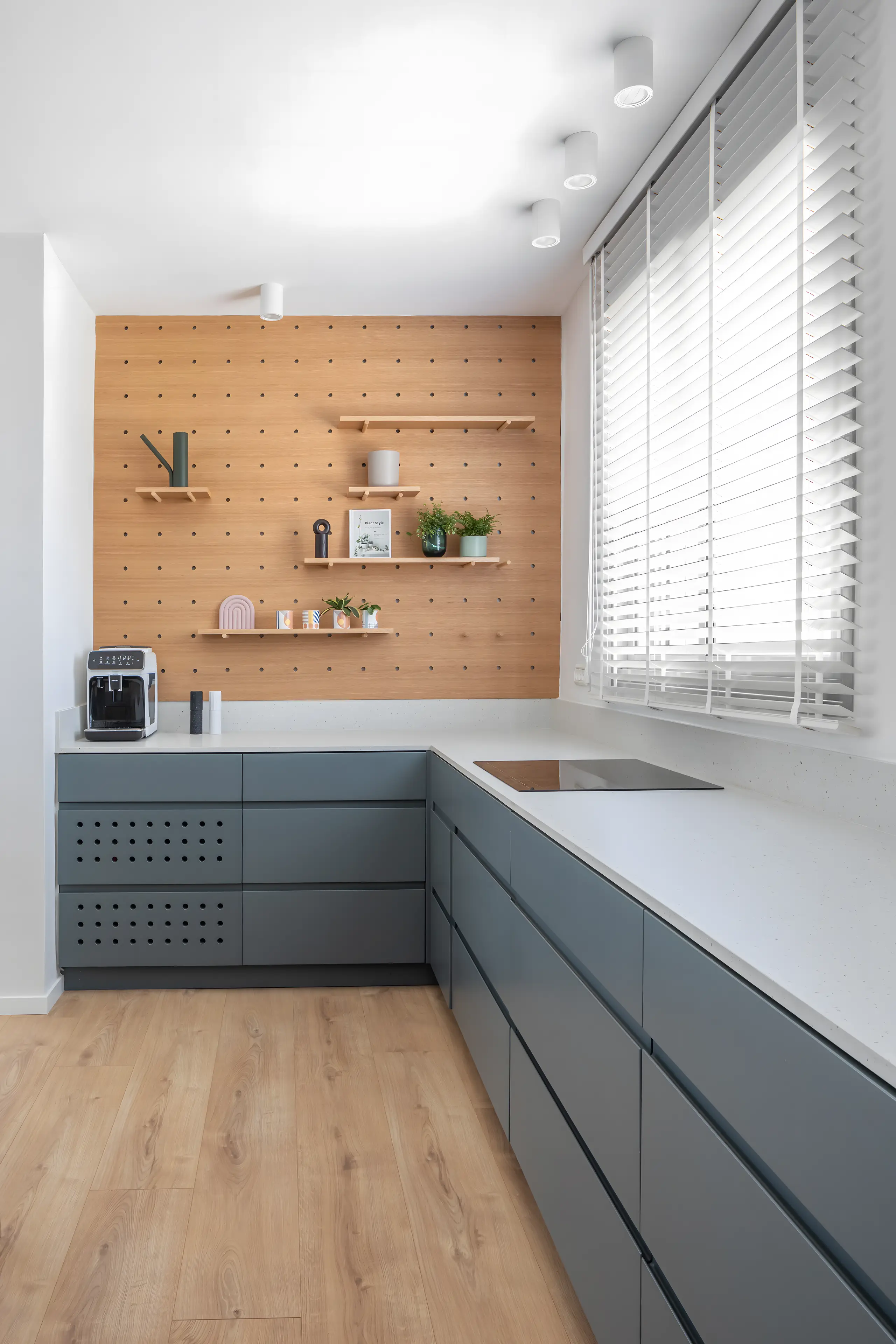 Dark grey kitchen with a pegboard wall and a white worktop