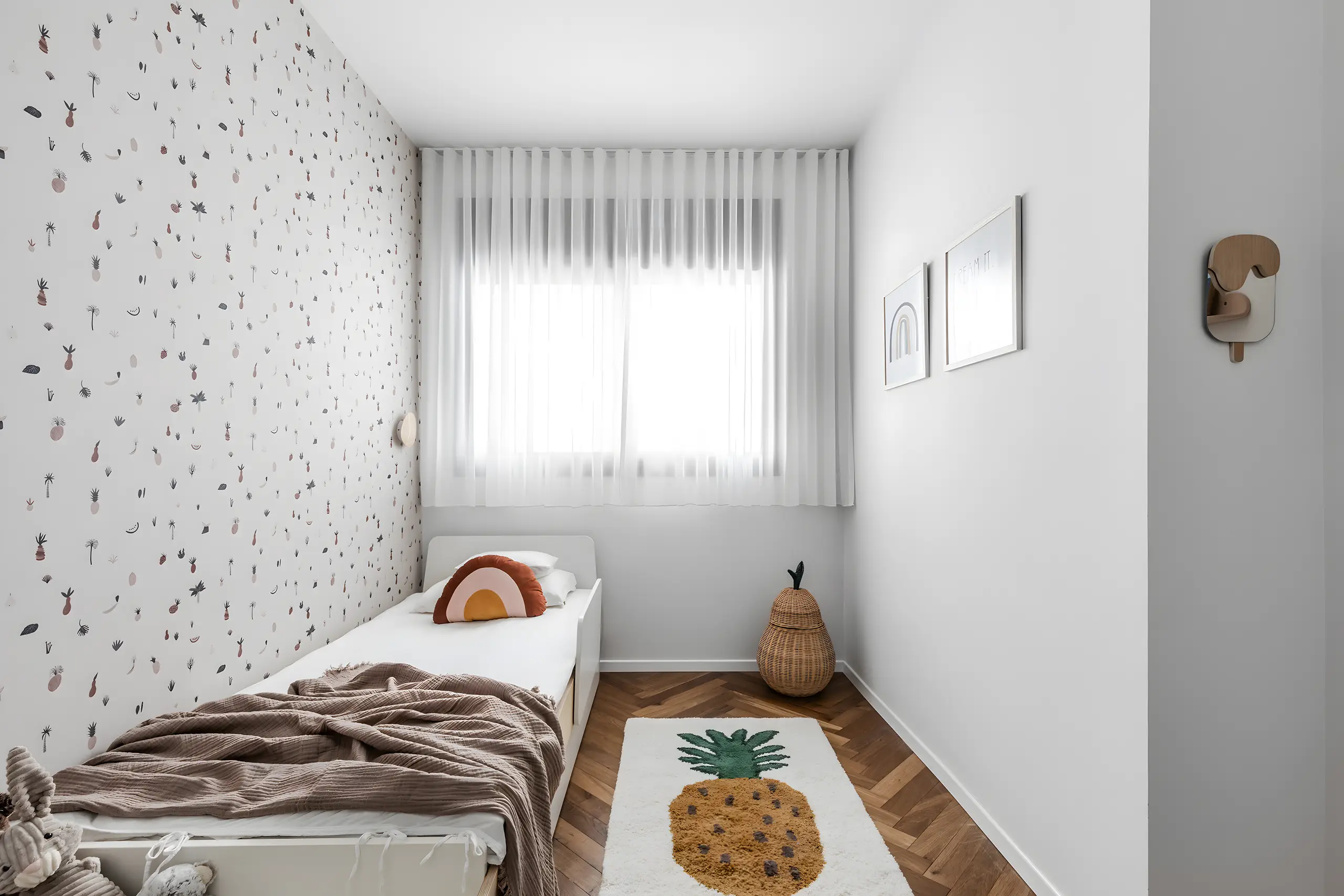 Child's room with a terrazzo-patterned wall and a bed by the window