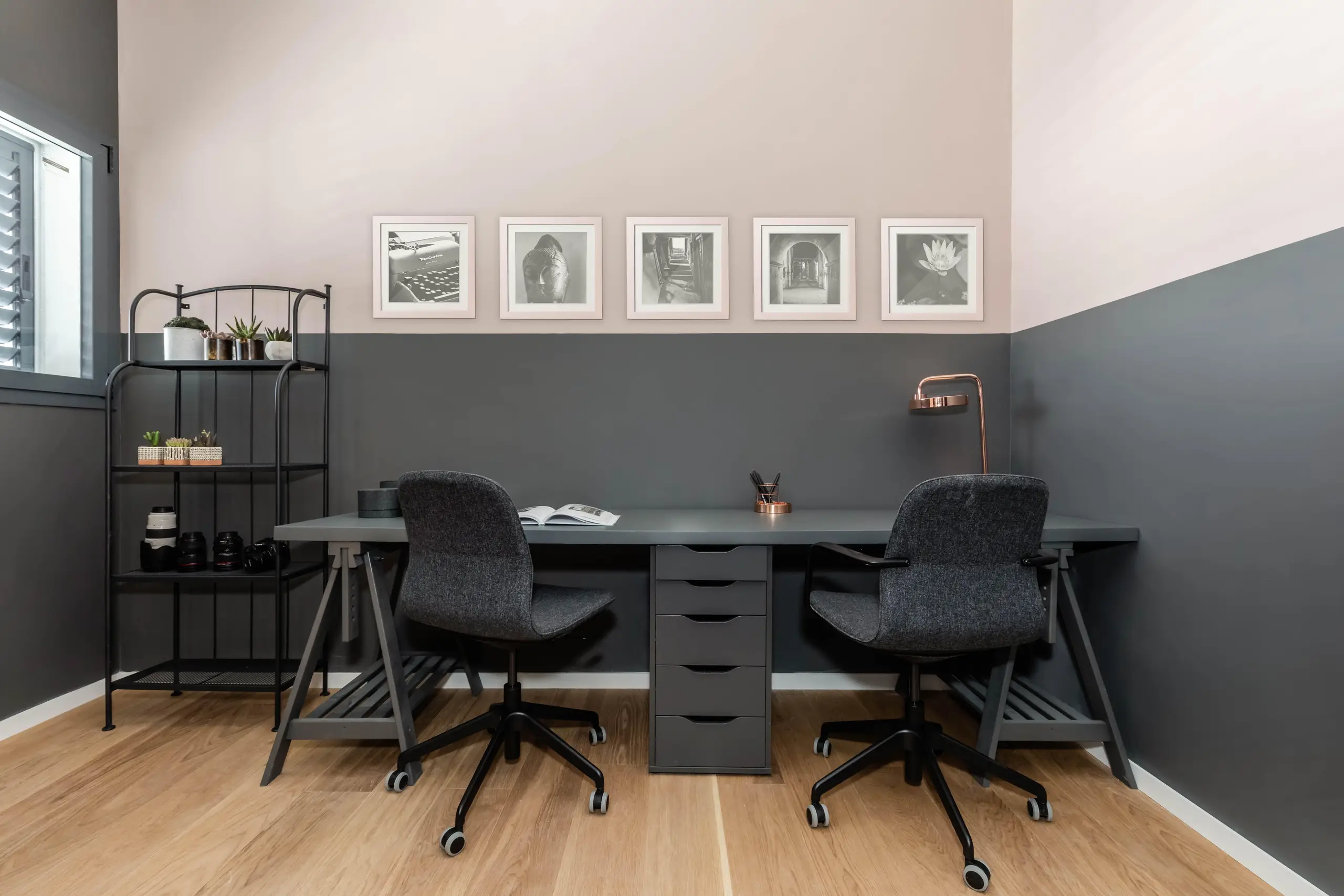 Study wall painted dark grey to desk height with two black chairs