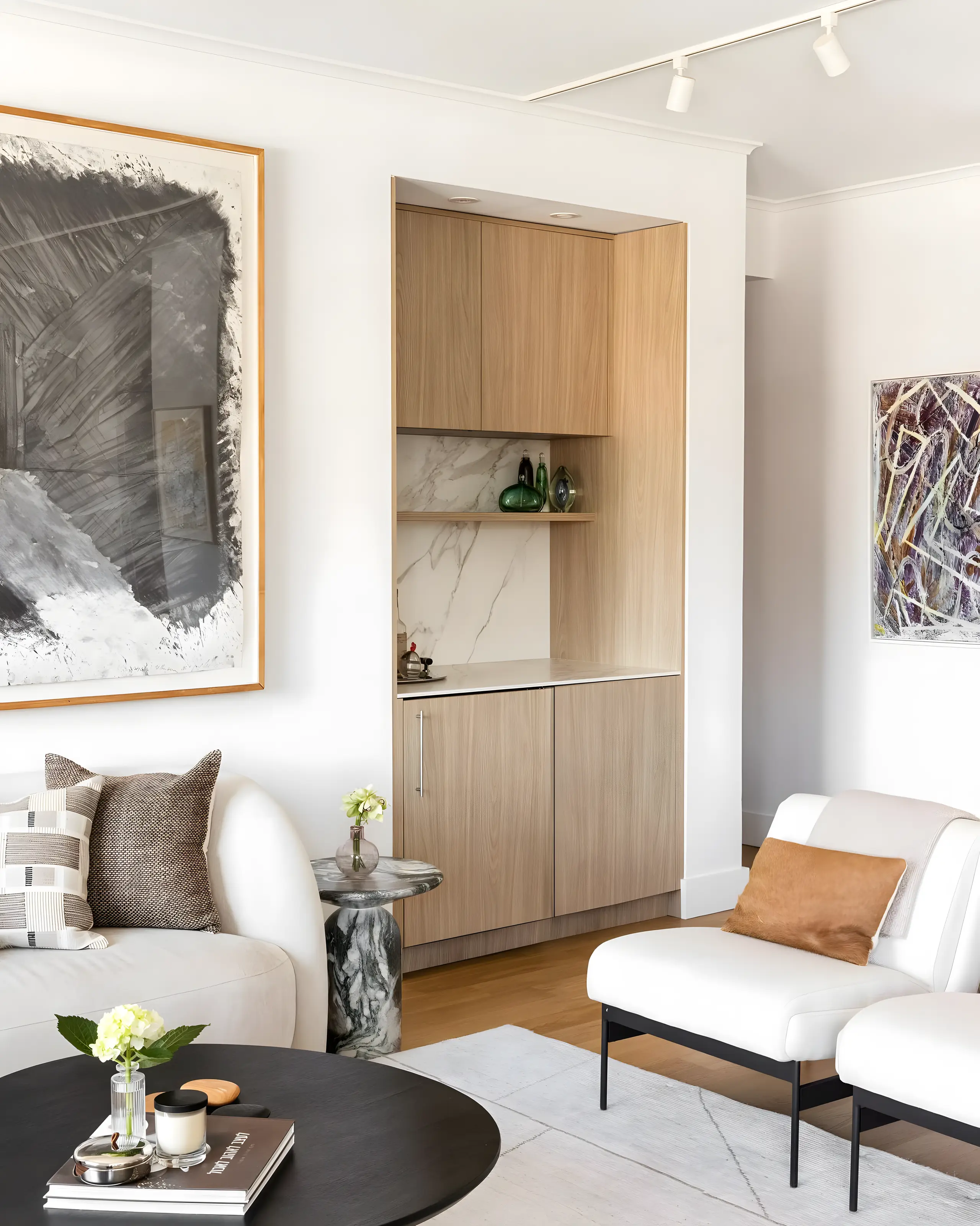 Custom oak millwork with a marble panel, a cushion and a small table in a quiet corner